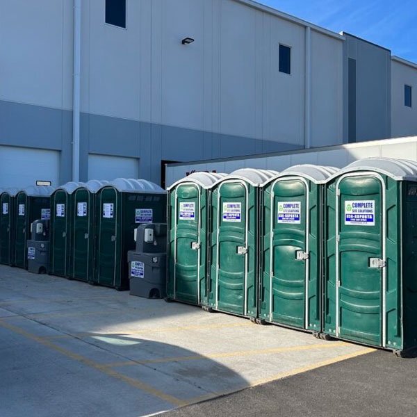 row of Complete Site Solutions portable toilets outside building