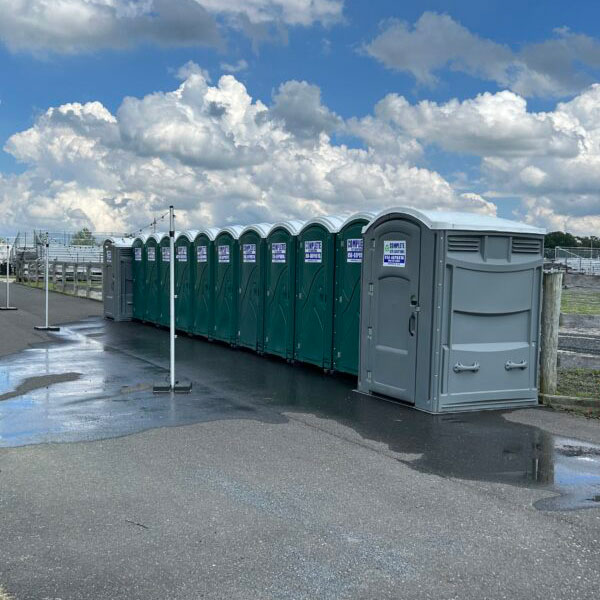 row of Complete Site Solutions portable toilets outside at event