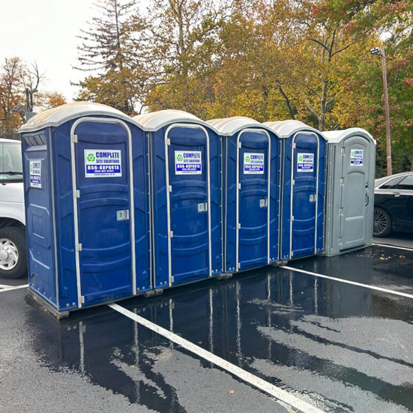 row of Complete Site Solutions portable toilets outside at event