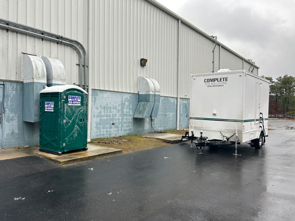 Complete Site Solutions restroom trailer and portable toilets outside of building