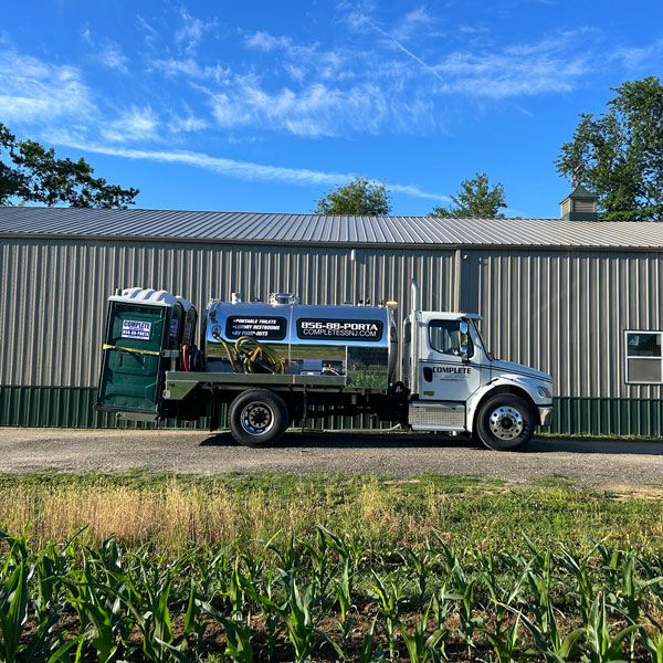 Complete Site Solutions truck hauling portable toilet