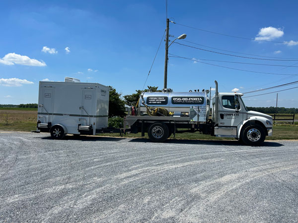 Complete Site Solutions truck hauling restroom trailer